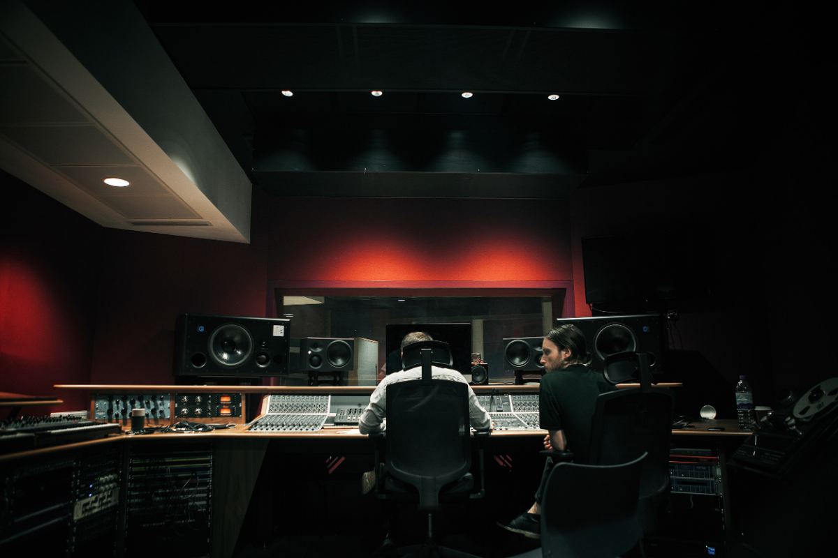Two people sat in a sound mixing studio