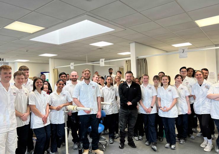 Alex Brooker standing with a large group of university students