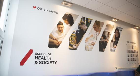School of Health and Society wall display in Allerton Building featuring images covering different subject areas