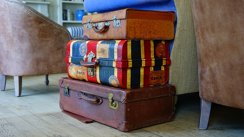 Pile of luggage on a wooden floor
