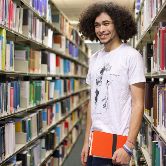A student in the library holding a book