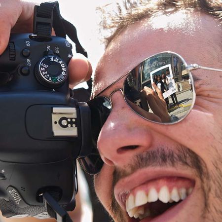 Photographer wearing sunglasses and a wide smile