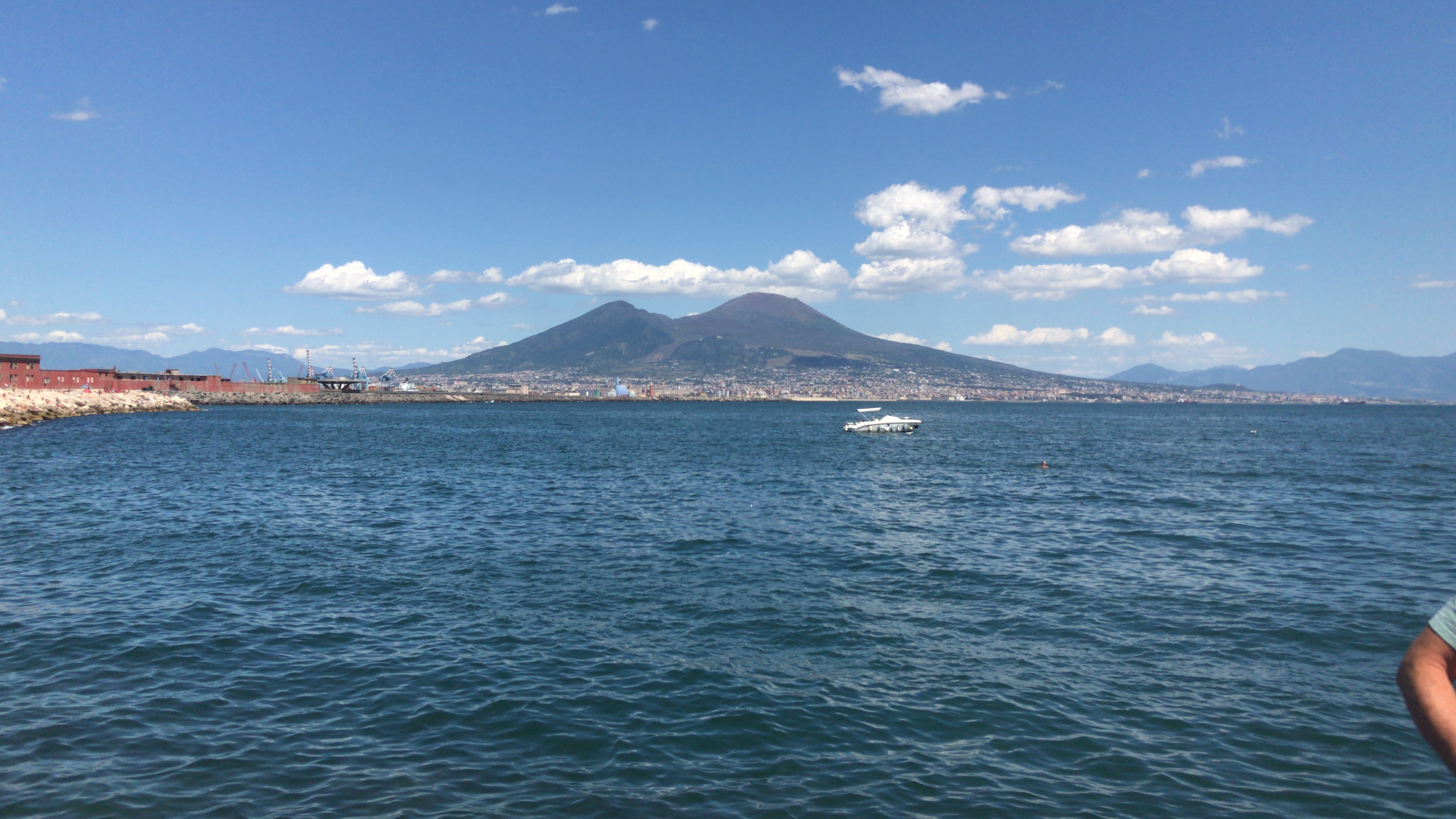 Ocean with a mountain in the background in Naples, Italy