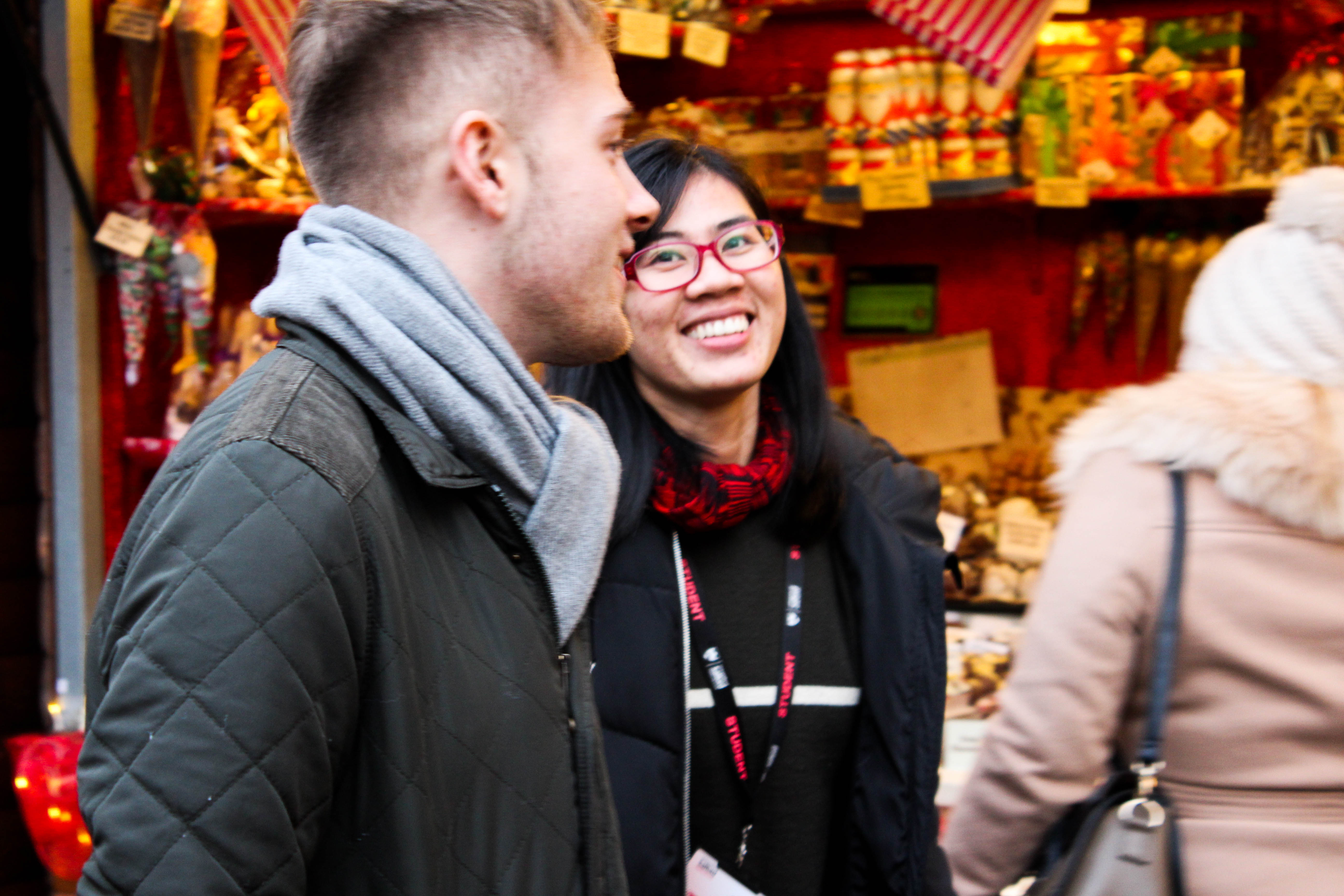 Two students stood outside a stall at the Manchester Christmas Markets