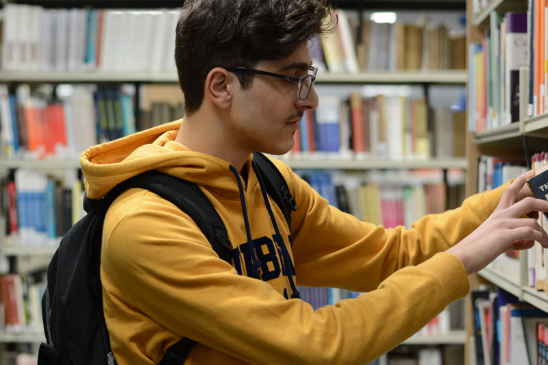 A student searches in the Library for books