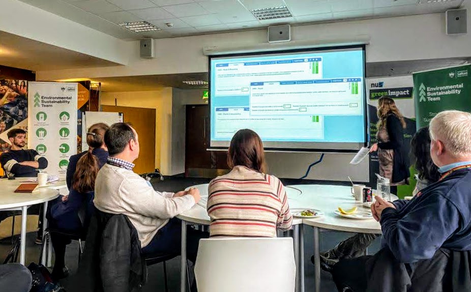 People sat at tables watching a presentation