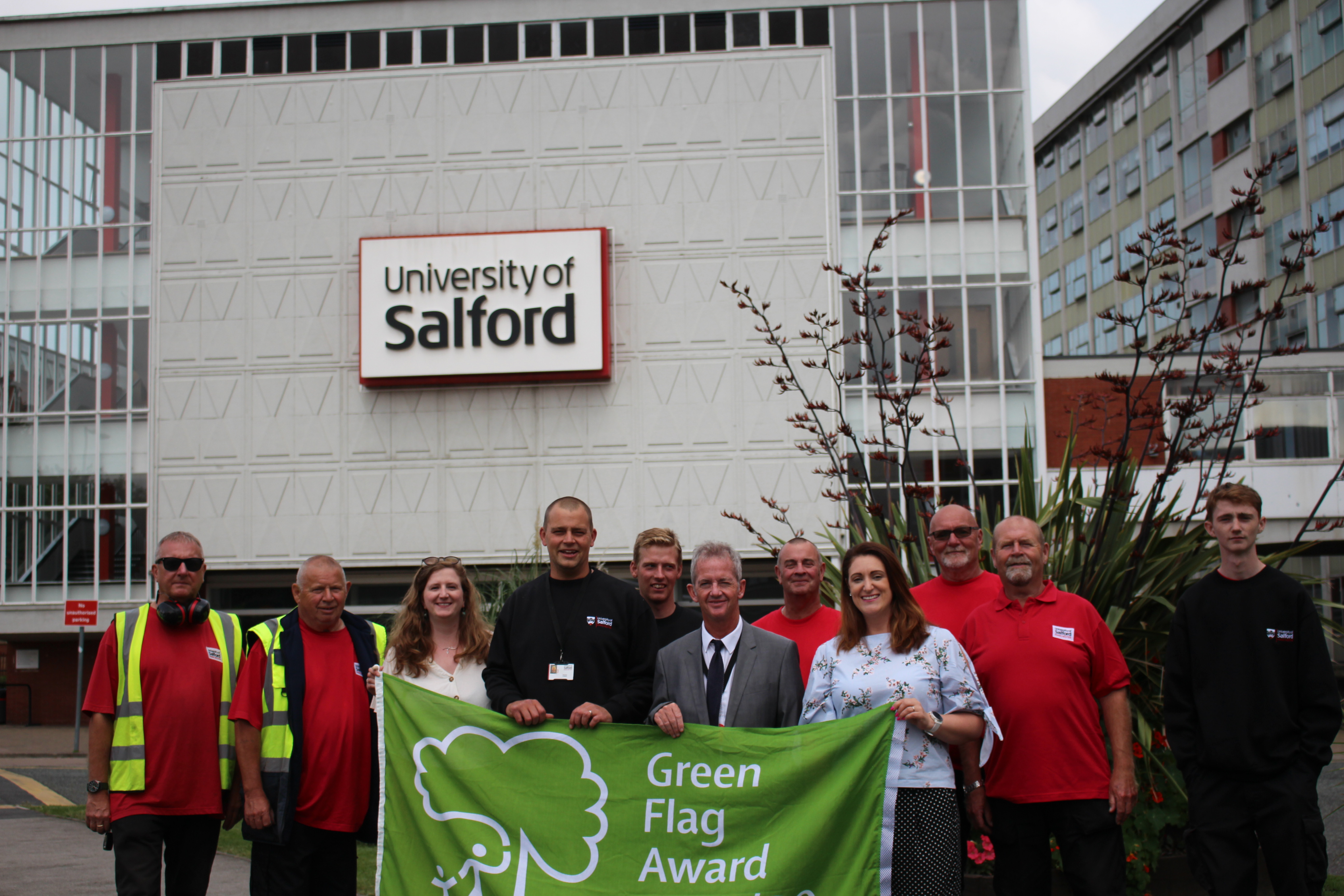 Group of Estates & Facilities staff stood with Green Flag 
