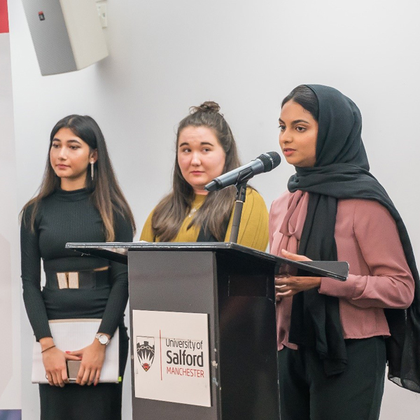3 students presenting at a SILKS event