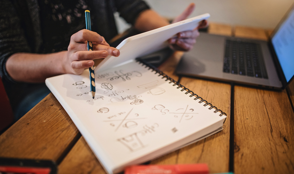 Person making notes on writing pad