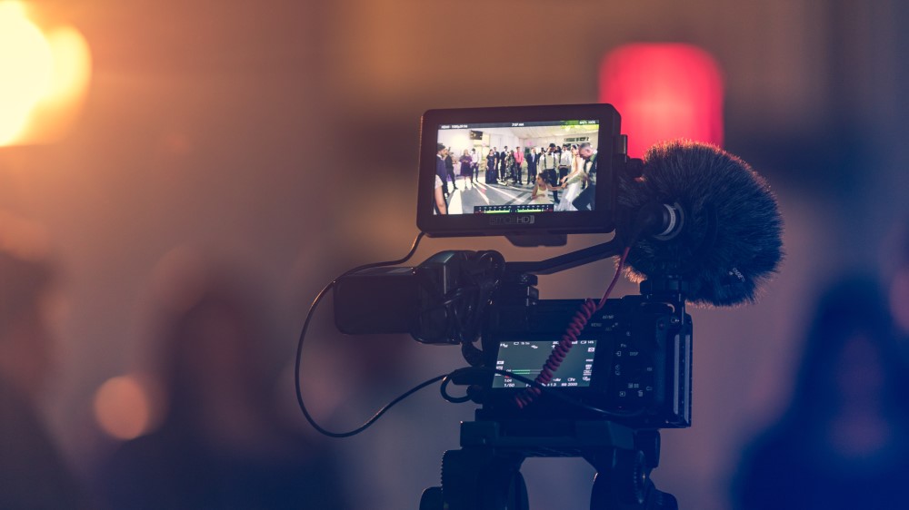 A camera screen shows a group of people