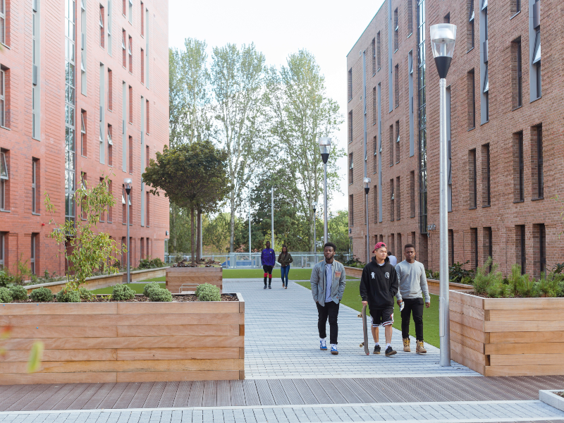 Students outside Peel Park Quarter student accommodation, University of Salford