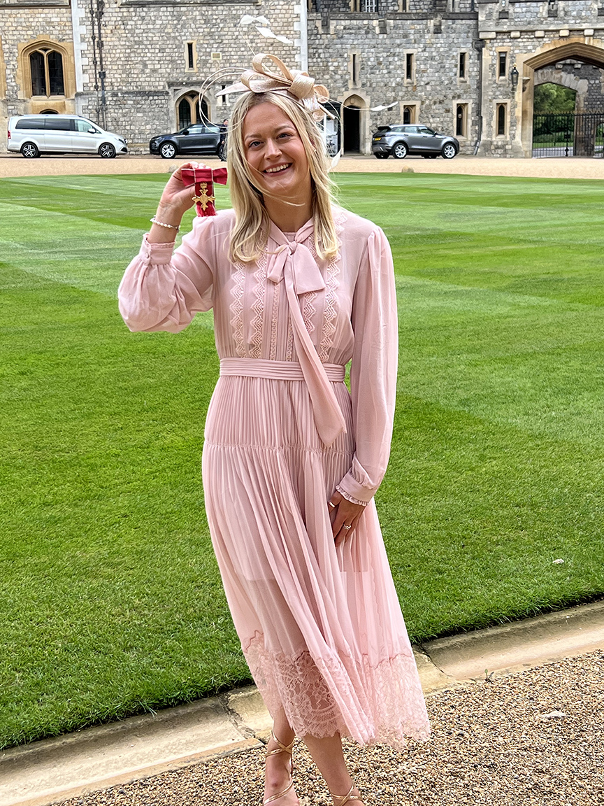 Hannah smiling with her OBE at Windsor Castle