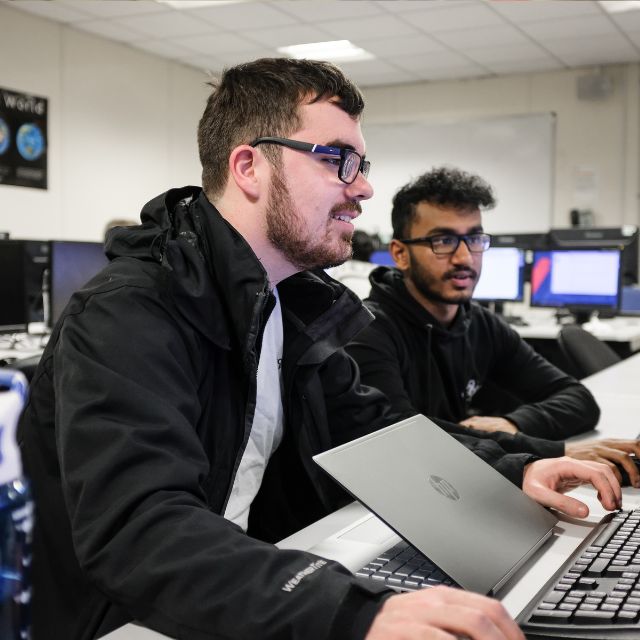 two maths students look at a computer screen 