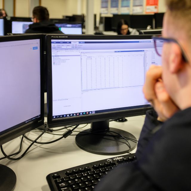 Maths student looking at his computer screen with data on