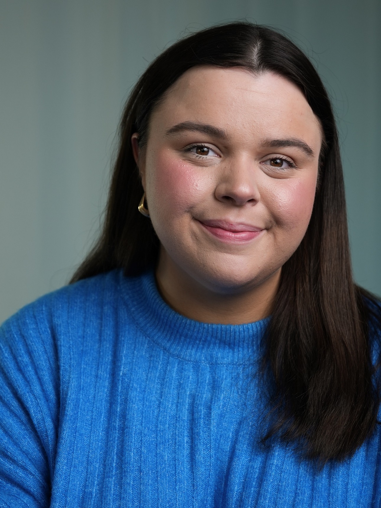 Girl with brown hair and blue jumper - an actors headshot
