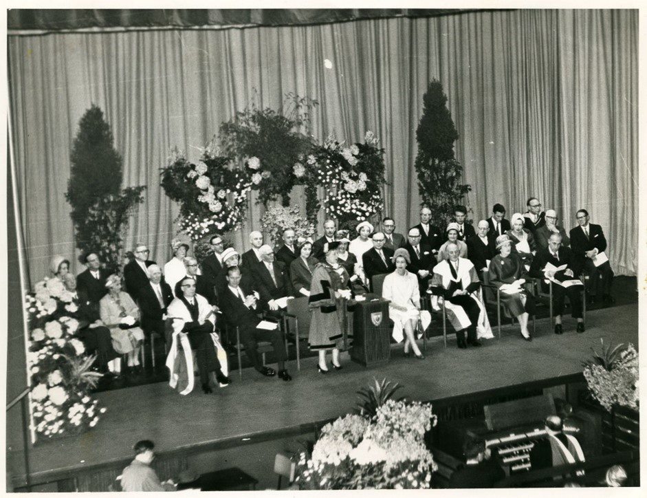 The Queen presenting on the stage at Maxwell Hall