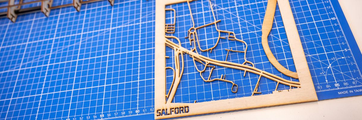 Laser cut map of salford on blue background
