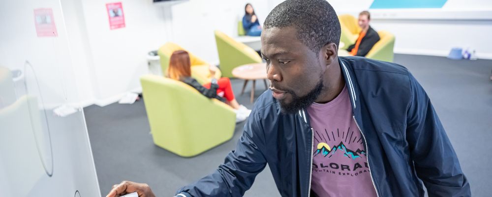 Business School Students. One student writing on a whiteboard. 