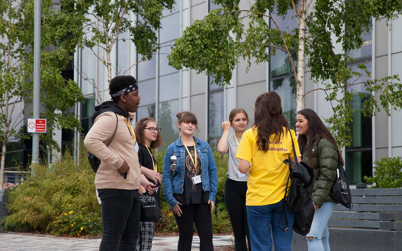 A group of students engaging in conversation with student ambassadors on campus