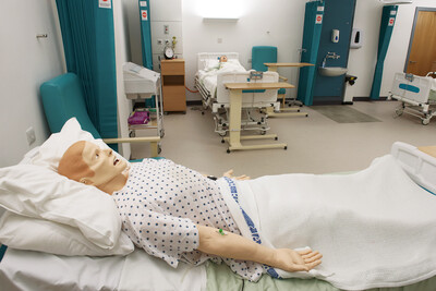 Nursing training doll in hospital bed in nursing simulation suite