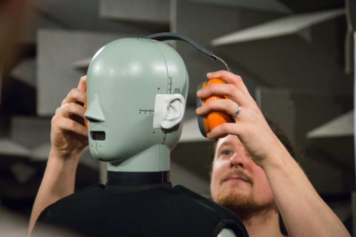 Man testing headphones on a robot