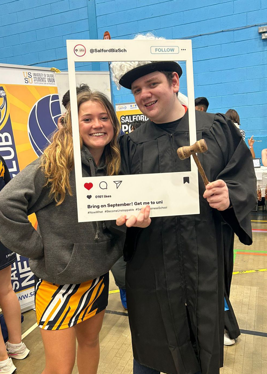 Student Alex and another student pose with a photo frame at the 2023 Welcome Week Societies Fair.
