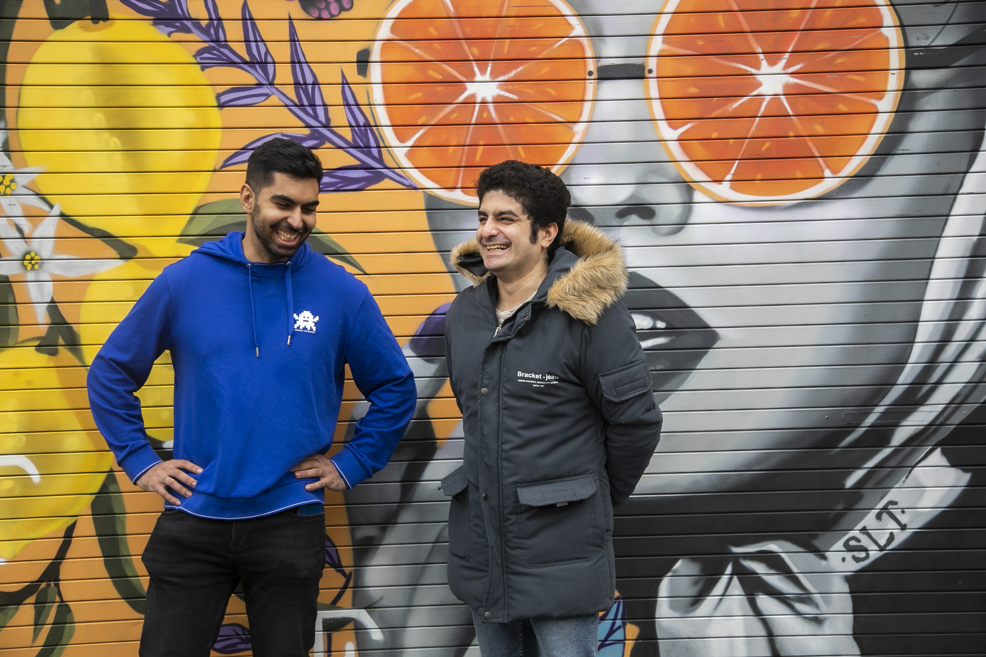 Two international students in front of graffiti