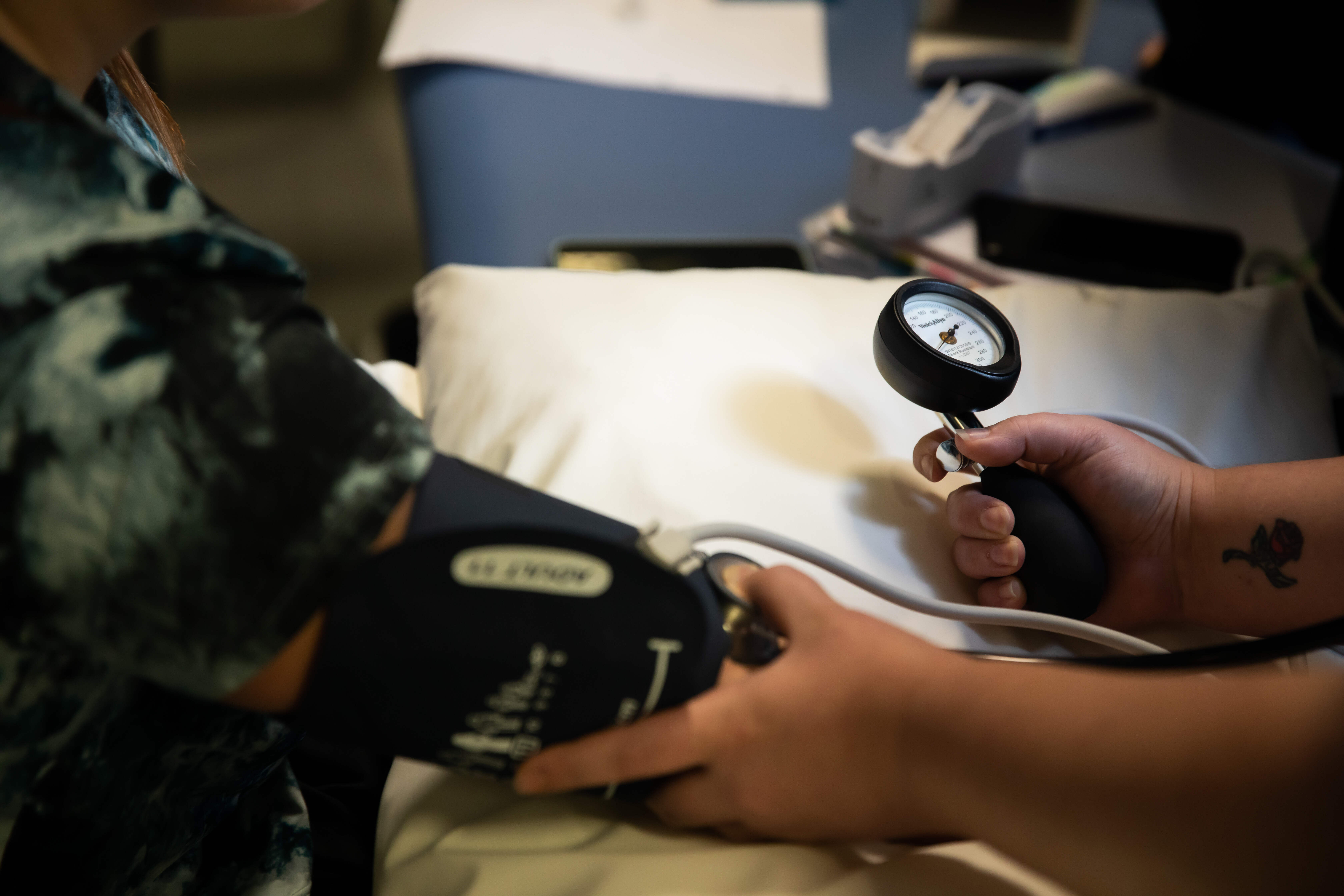 An apprentice taking a patient's blood pressure 
