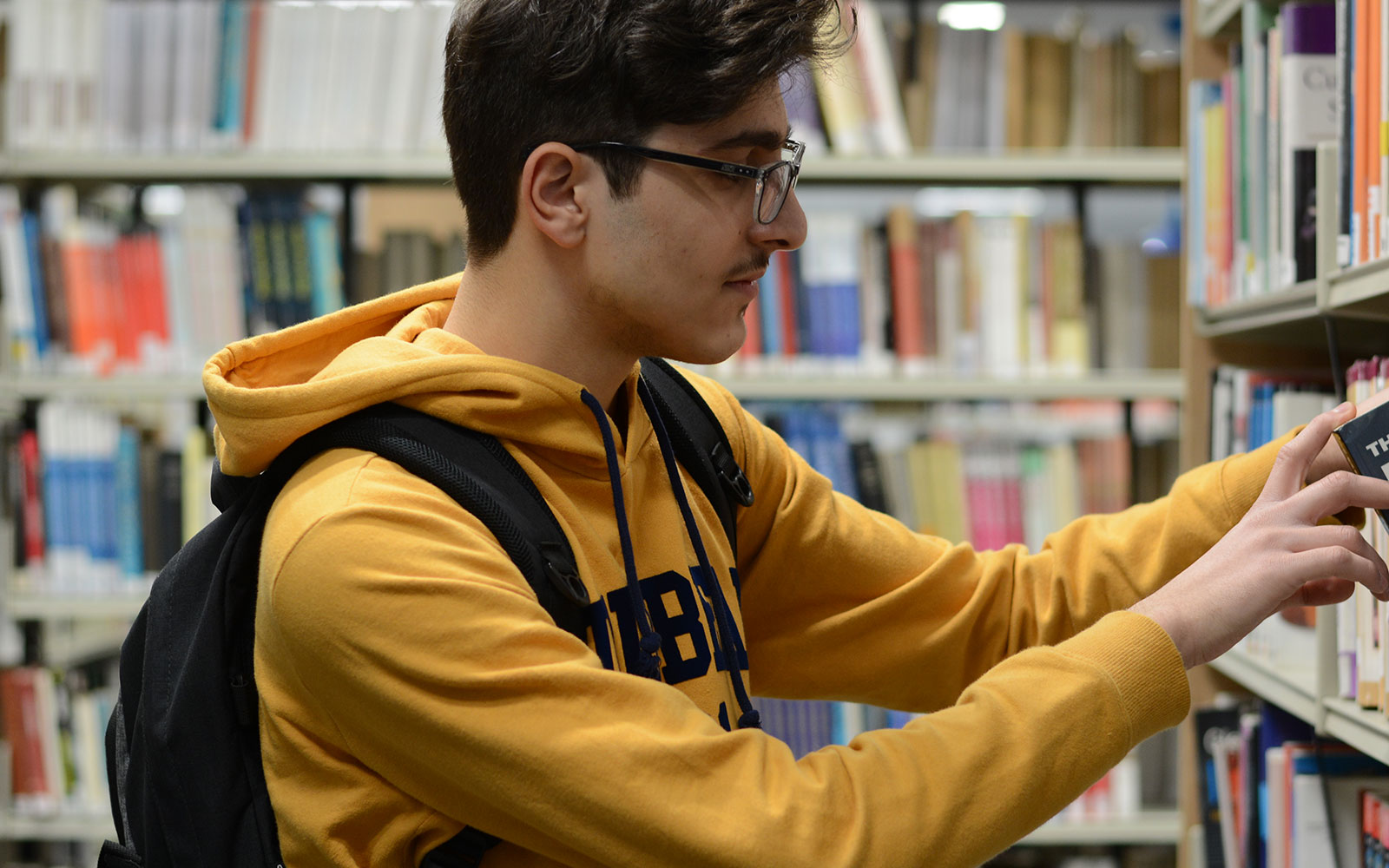 Student searching for books in a library
