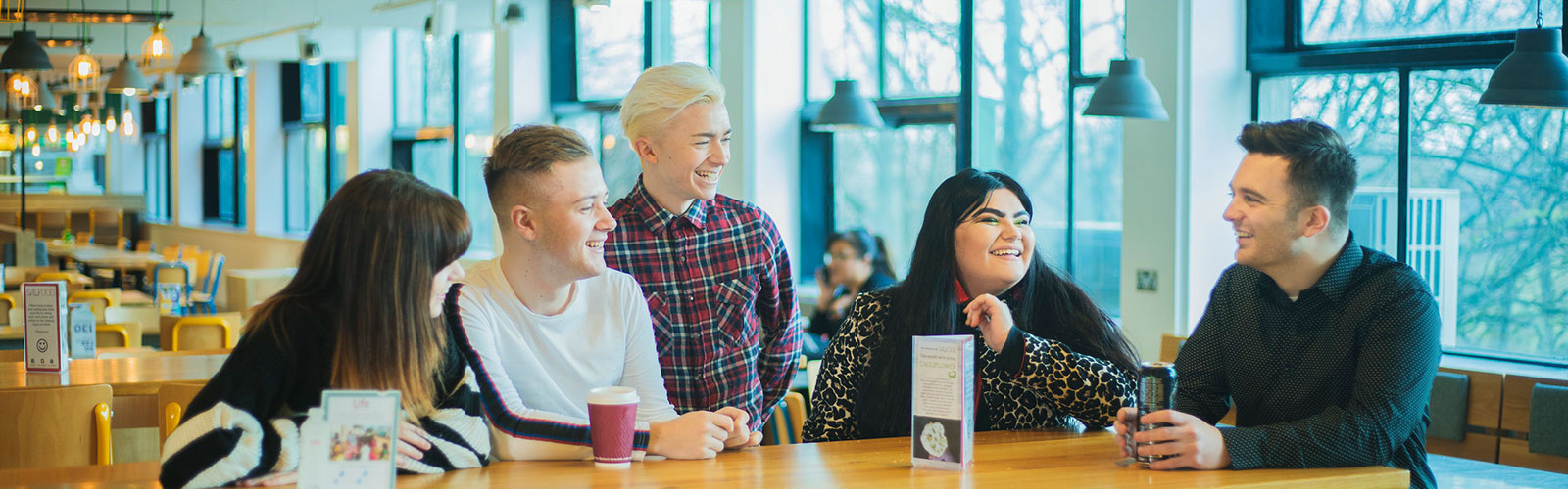 Five students socialising around a table in Maxwell cafe