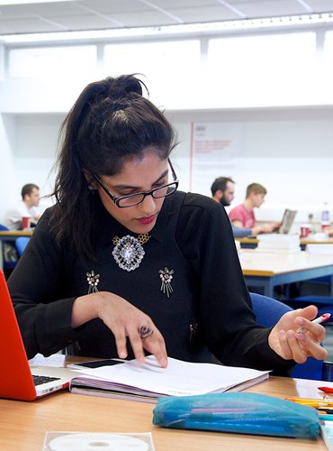 Student studying at her desk in the library