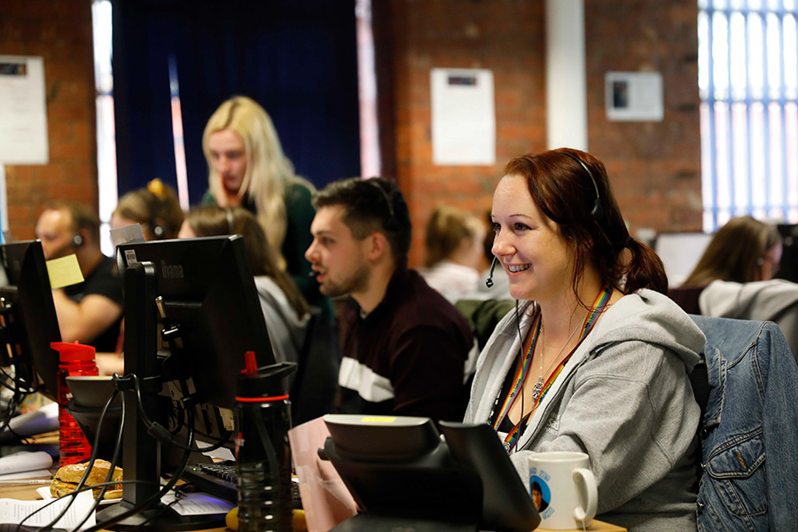 University of Salford Clearing team sat at computers with headsets answering calls and enquiries.