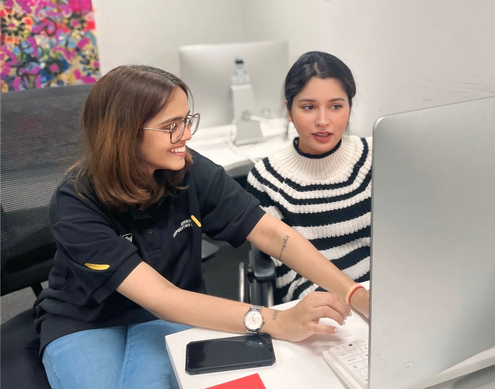 Two students working on a computer 