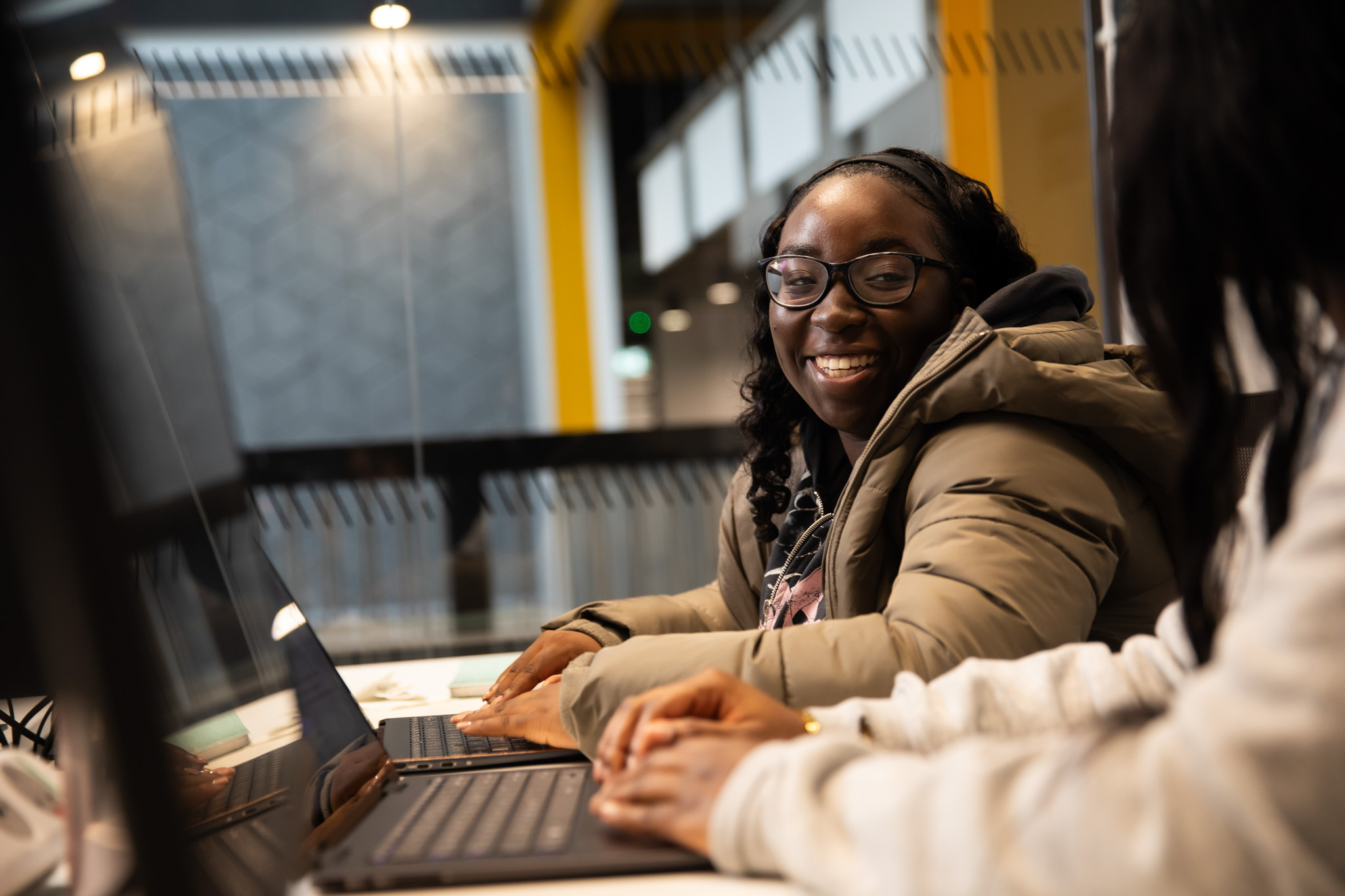 Student sat smiling in front of their computer screen