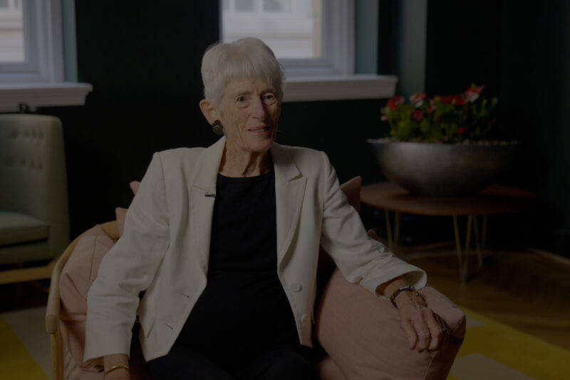 Jean Oglesby, sitting and smiling to camera