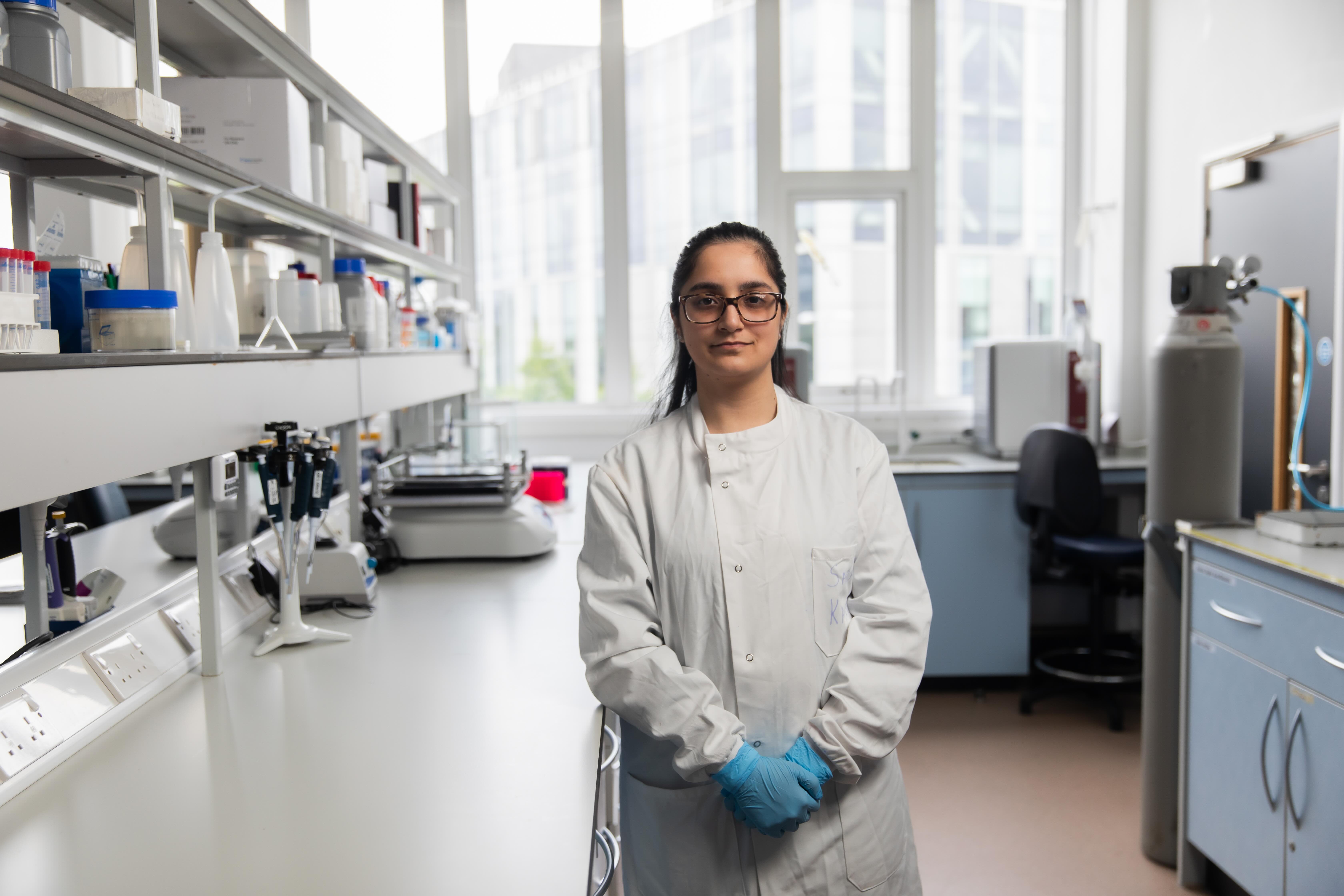 Biomedical science student Sara sitting in a lab at the university of Salford