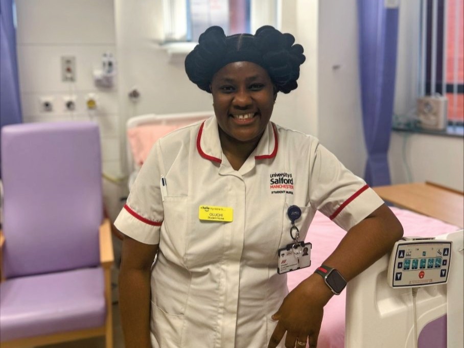 Oluchi smiles towards the camera, she is wearing a student nurse uniform and is pictured in the simulation suites