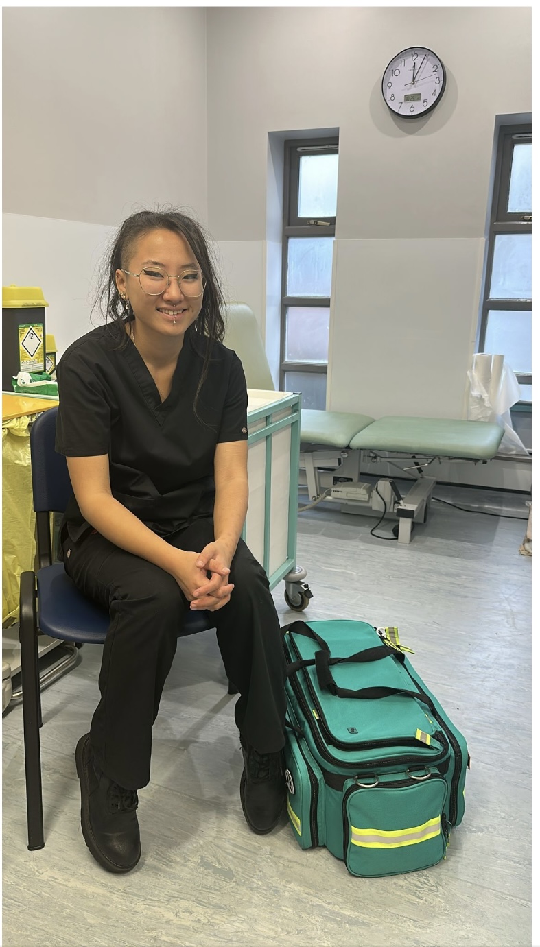 Vita Murray is pictured sitting on a chair in a clinical setting. She smiles at the camera