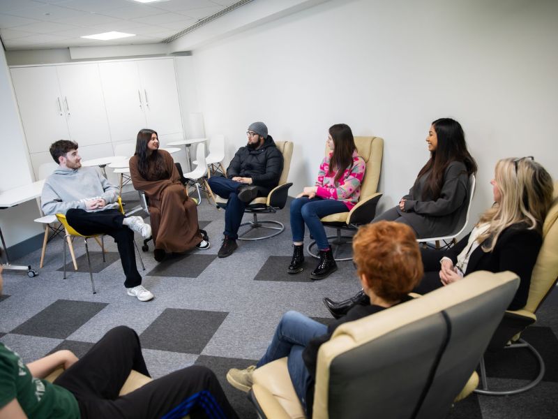 A group of people sat in a circle talking