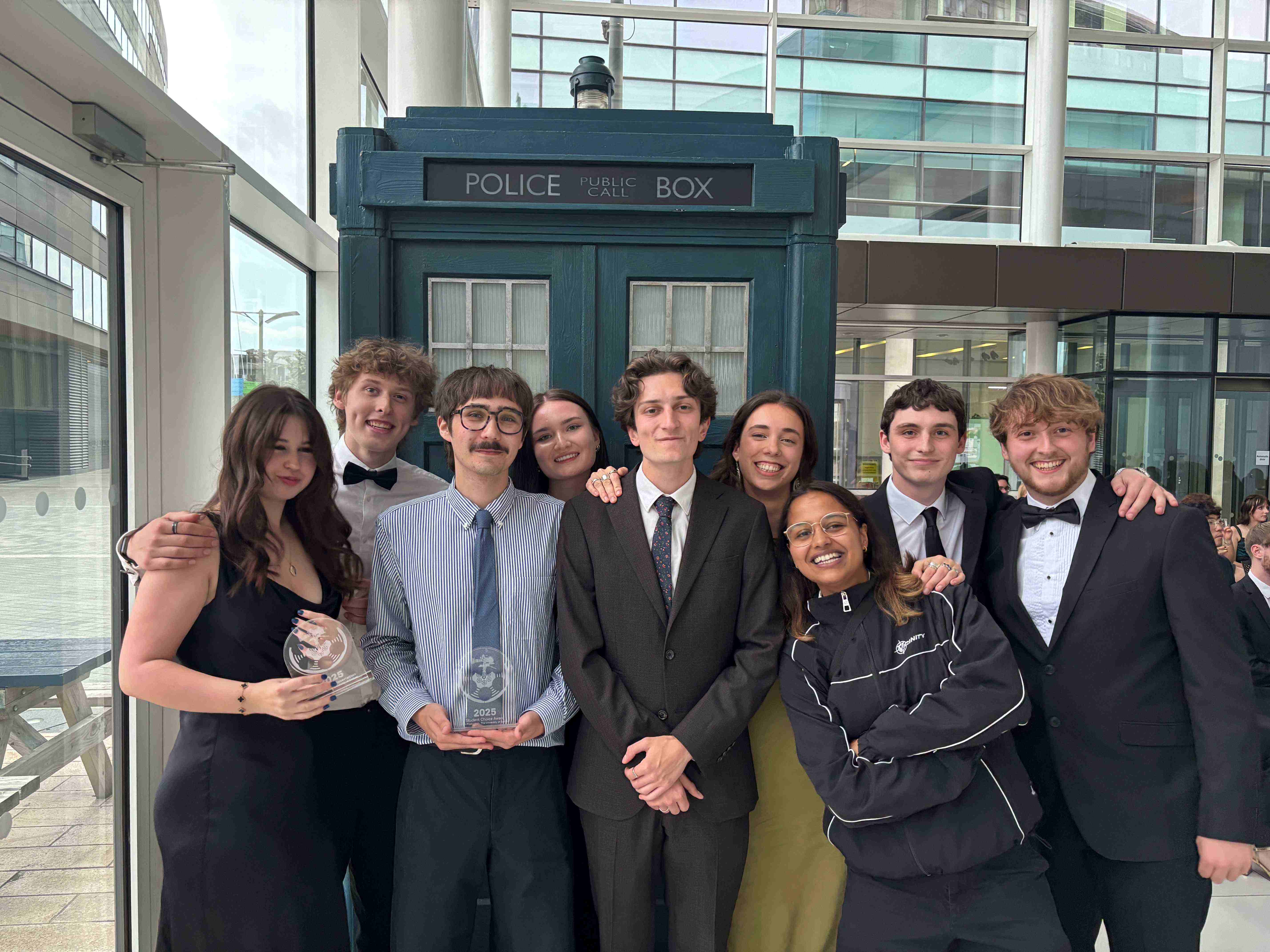 A group of students looking at the camera holding glass awards at the Film Production Awards 2025