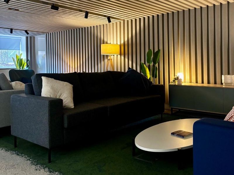 Two sofas face each other with a coffee table in between them, soft lighting and plants in the background