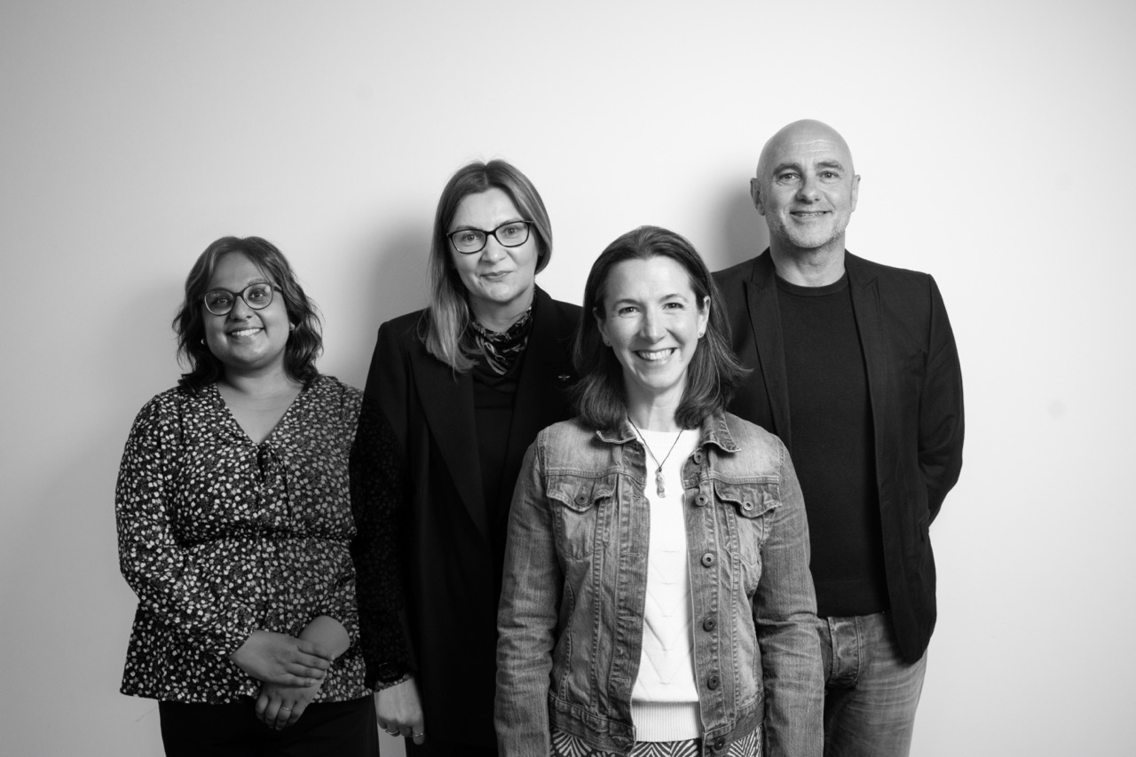 This image shows a group of individuals posed together. Three women and a man.