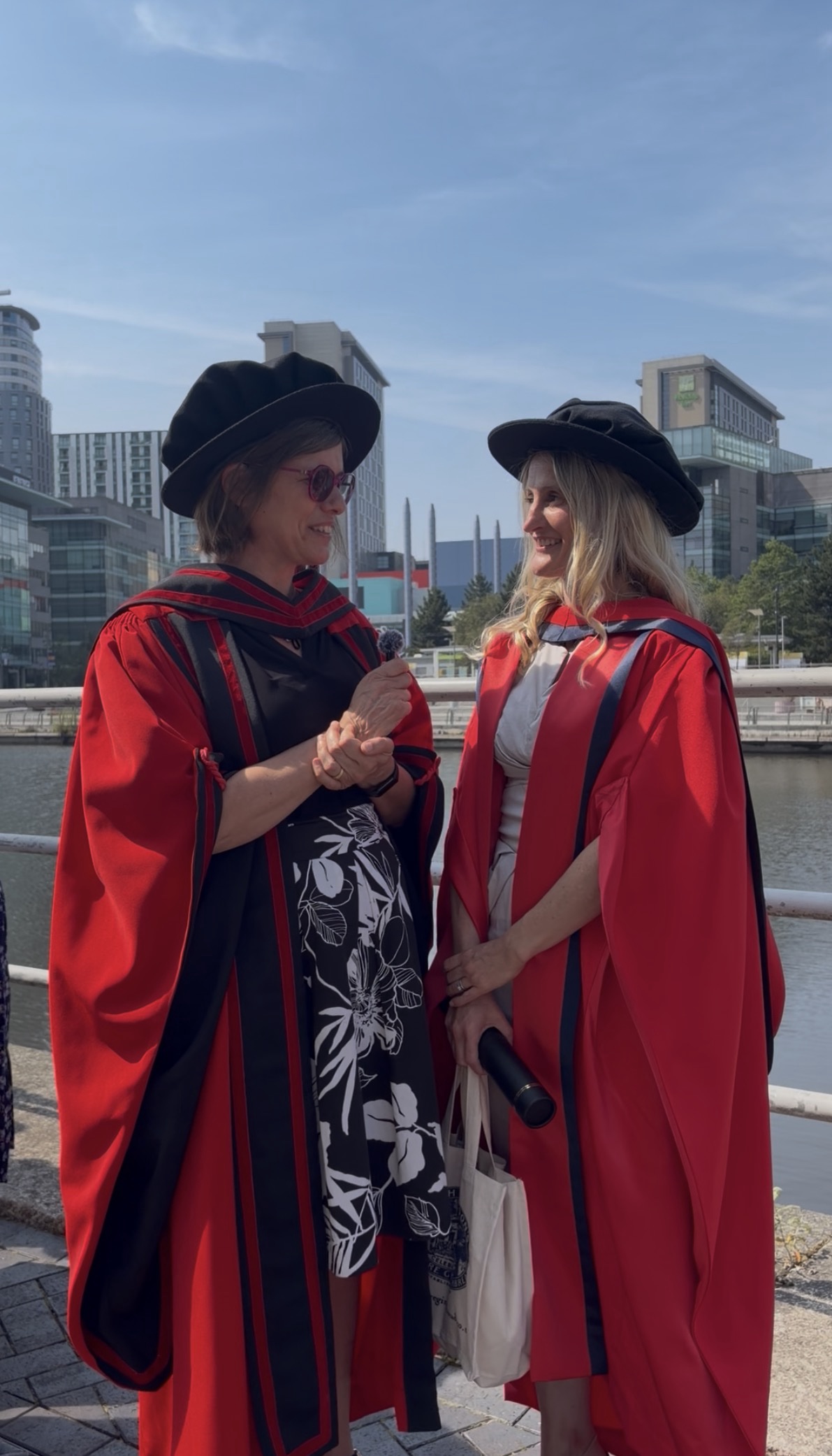 Penny Cook and Bryony O'Connor in red graduation gowns