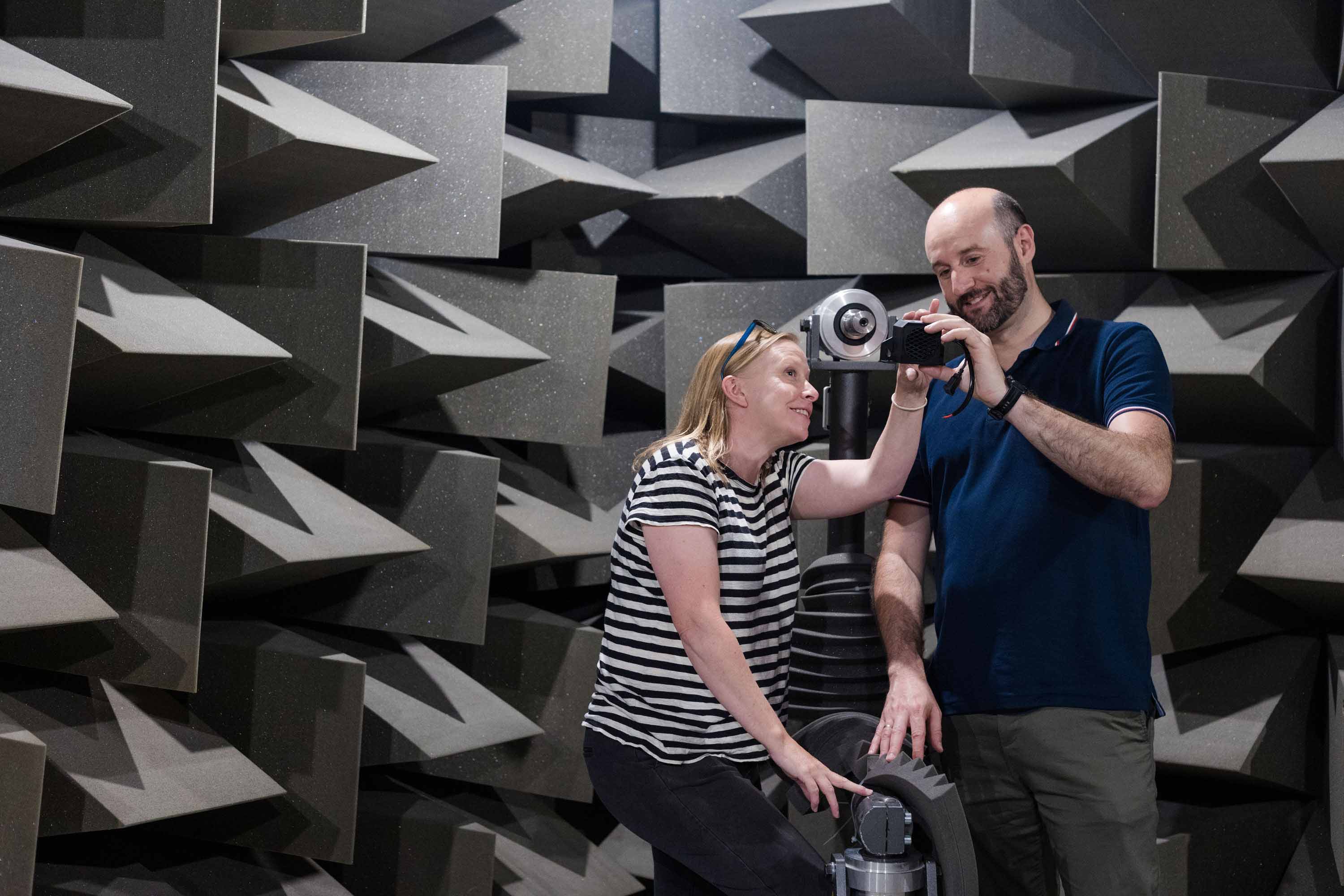 Two students working on equipment in the anechoic chamber, Newton Building, University of Salford