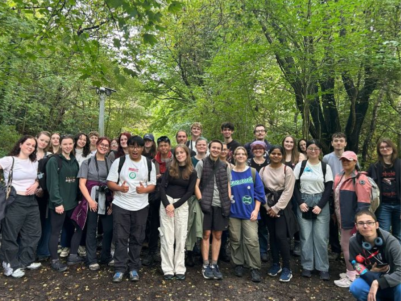 A large group of students in a wooded area during a bird walk