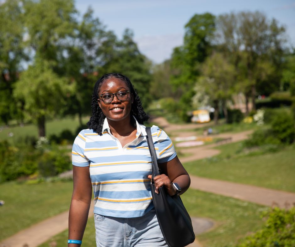 International student walking through Peel Park Campus, University of Salford