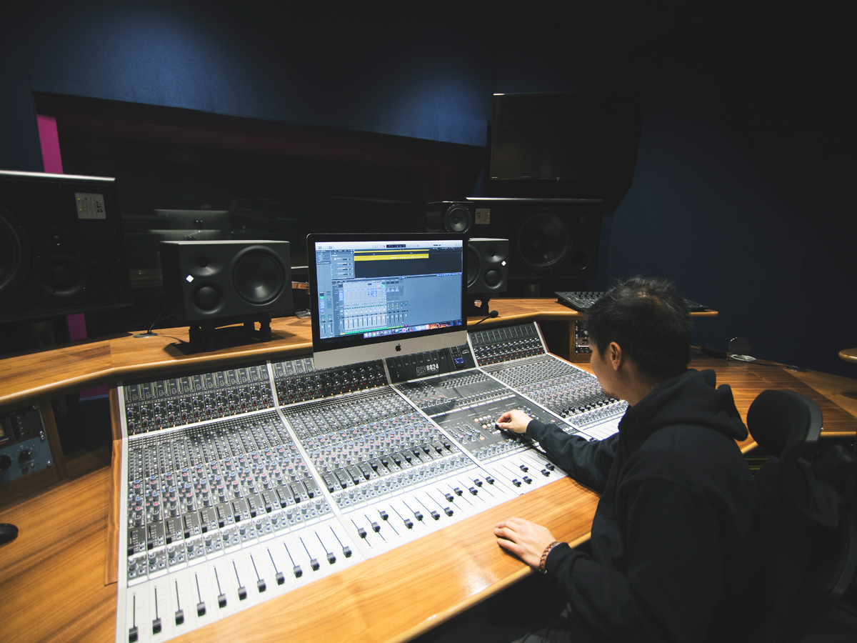 A music degree student works in a recording studio.