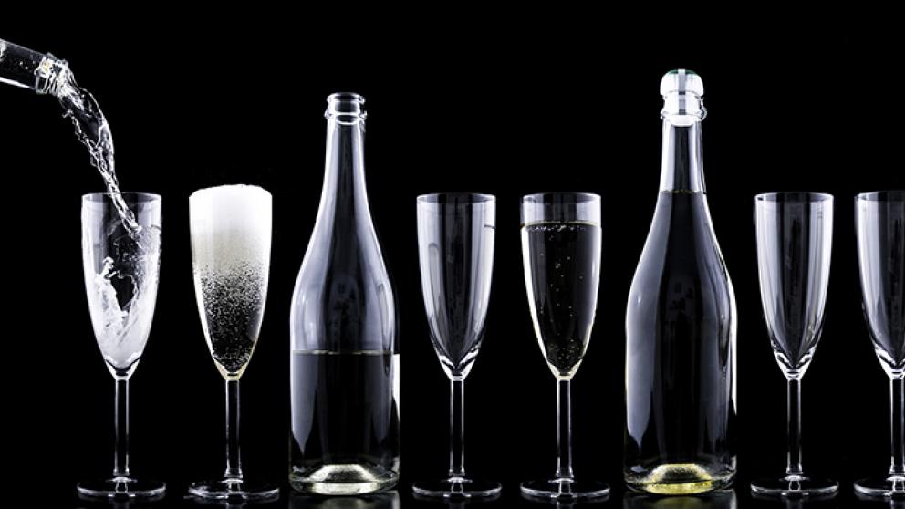 Bottle pouring champagne into glasses