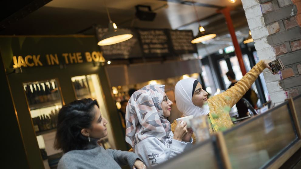 Students taking a selfie in Mackie Mayor market, Manchester