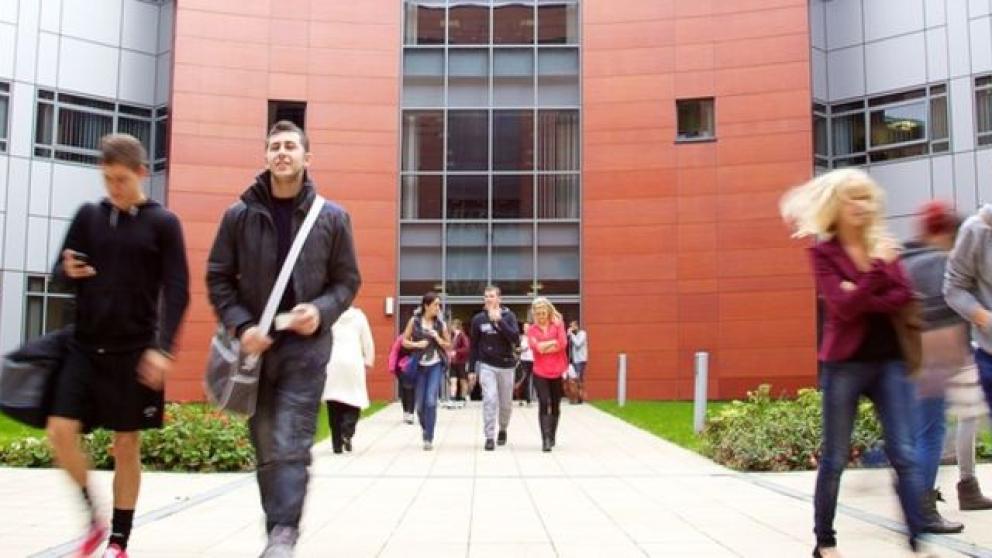 Multiple people outside the entrance to the Mary Seacole Building, University of Salford